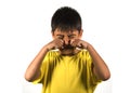 7 or 8 years old male child crying helpless and sad isolated on white background wearing yellow t-shirt in kid scolded and nagged