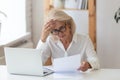 60 years old serious businesswoman reading document holding ache. Royalty Free Stock Photo