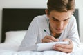 16 years old teenage boy writing school notes or doing homework Royalty Free Stock Photo