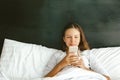 12-14 years teenag girl using smartphone in bed Royalty Free Stock Photo