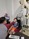 KUALA LUMPUR , MALAYSIA - JUL 26, 2020: Optometrist check 9 years old asian boy eye test exam for short sighted during Covid 19