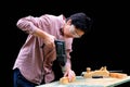 50 years old woman carpenter drilling a hole with an electric drill machine in wooden plank. Woodwork, DIY, gender equality Royalty Free Stock Photo