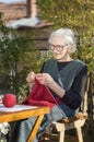 90 years old woman knitting a red sweater Royalty Free Stock Photo