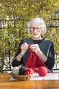 90 years old woman knitting a red sweater Royalty Free Stock Photo