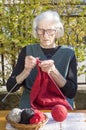 90 years old woman knitting a red sweater Royalty Free Stock Photo