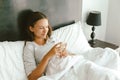 12-14 years teenag girl using smartphone in bed Royalty Free Stock Photo