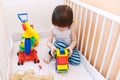 2 years toddler playing cars in white bed