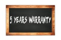 5 YEARS WARRANTY text written on wooden frame school blackboard