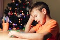 7 yeas old boy sitting at desk and reading book