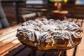 Yeast braid in the sun designed like a flower or star on a wooden plate with a tree and easter eggs in the background