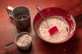 Yeast bread dough in a bowl with flour, yeast, sugar and flour sieve on kitchen table. Preparation of homemade bread. Royalty Free Stock Photo