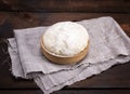 Yeast dough in a wooden bowl on a gray napkin Royalty Free Stock Photo