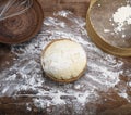 Yeast dough in a wooden bowl and a round vintage sieve