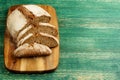 Yeast free, no knead, unleavened healthy organic rye wheat half sliced homemade bread loaf on kitchen board on green Royalty Free Stock Photo