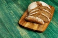Yeast free, no knead, unleavened healthy organic rye wheat half sliced homemade bread loaf on kitchen board on green Royalty Free Stock Photo