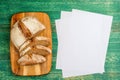 Yeast free, no knead, unleavened healthy organic rye wheat half sliced homemade bread loaf on kitchen board on green Royalty Free Stock Photo