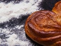 Yeast sweet buns in the shape of a heart on black baking tray. Country house style. Authentically