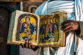 Yeha, Ethiopia - Feb 10, 2020: an orthodox priest shows a painted holy bible in the Great Temple of the Moon