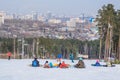 Young snowboarders are resting on the top of the ski slope of Uktus. Below is a beautiful panorama of the city of Yekaterinburg