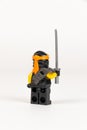 Toy hero Cole in a black kimono with a sword from a set of lego ninjago on a white background Royalty Free Stock Photo