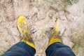 Yelkow Muddy rubber boots on wet silt