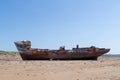 YELLAND, NORTH DEVON, UK - MAY 28 2020: Abandoned broken ship wreck, on sandy shore. Rusting hull on beach. Profile.