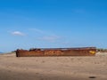 YELLAND, NORTH DEVON, UK - MAY 28 2020: Abandoned broken ship wreck, on sandy shore. Rusting hull on beach. Profile.