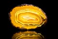 Yellow agate slice, black background, healing stone and mineral Royalty Free Stock Photo