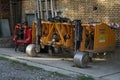 Yellow agriculture soil spading machine parked near the brick wall. Royalty Free Stock Photo