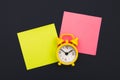 Yellow alarm clock and colorful sticky notes on a blue background. The concept of working time. Workplace Royalty Free Stock Photo