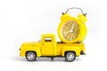 A yellow alarm clock in a toy truck. White background with copy space for text. Deadline and the concept of timeliness