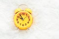 Yellow alarm clock on white wool. Late and Lazy time concept. Mo Royalty Free Stock Photo