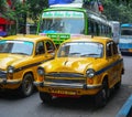 Yellow Ambassador taxi cars go on the street in Kolkata Royalty Free Stock Photo