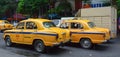 Yellow Ambassador taxi cars go on the street in Kolkata Royalty Free Stock Photo