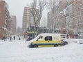 Yellow ambulance stranded in the snow and ice on the roads of Madrid due to the snowfall in the capital of Spain. Cold winter.