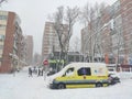Yellow ambulance stranded in the snow and ice on the roads of Madrid due to the snowfall in the capital of Spain. Cold winter.