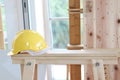 Yellow antiknock helmet on wooden table at carpentry woodwork workshop, personal protective equipment PPE at work place concept Royalty Free Stock Photo