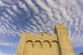 The yellow antique brick building of church under wave of softy and white fluffy clouds  deep blue sky background Royalty Free Stock Photo