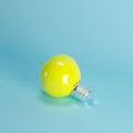 Yellow apple light bulb floating on blue background