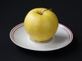 Yellow apple on plate Royalty Free Stock Photo