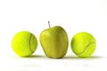 Yellow apple between two tennis balls Royalty Free Stock Photo