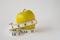 Yellow apple on white background with measuring tape Royalty Free Stock Photo