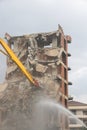 Yellow arrow of a crane and a stream of water on the dismantling of an unfinished high building, Turkey, Alanya