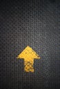 Yellow arrow painted pointing up on steel checkered plate Royalty Free Stock Photo