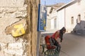 Yellow arrow painted on a stone made wall and a pilgrim woman on the way to Santiago