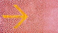 Yellow arrow sign on old cracked red leather texture. Royalty Free Stock Photo