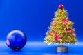 Yellow artificial Christmas tree decorated with red glittering a