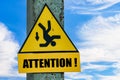 Yellow Attention sign with a falling man hanging on a pole, blue sky background with copy space Royalty Free Stock Photo