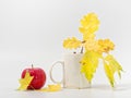 Yellow autumn leaves with red apples on a white background Royalty Free Stock Photo