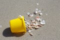 A yellow baby bucket and a red shovel stand on the sand by the sea Royalty Free Stock Photo